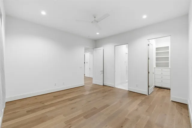 an empty room with wooden floor and white walls