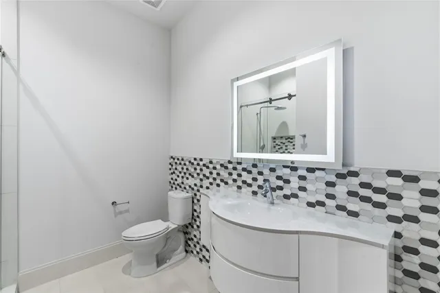 a bathroom with a granite countertop sink a shower and a mirror