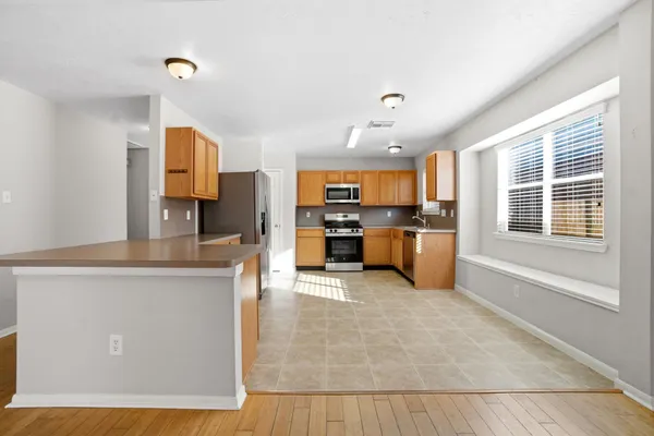 a kitchen with stainless steel appliances granite countertop a stove top oven a sink a counter space and cabinets