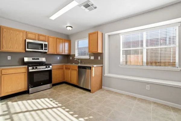 a kitchen with stainless steel appliances granite countertop a stove a sink and a microwave