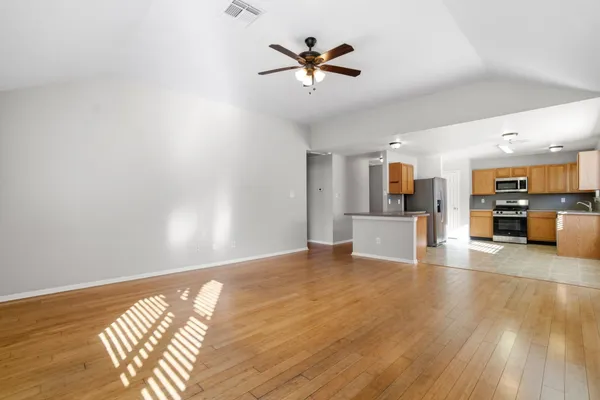a view of a livingroom with a ceiling fan and wooden floor
