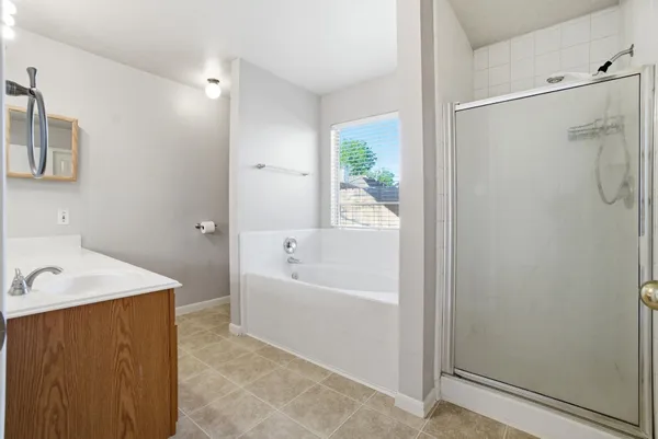 a bathroom with a tub a sink and a shower