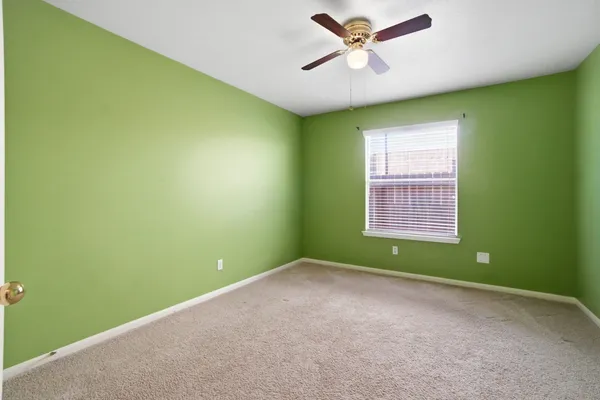 a view of a room with a ceiling fan and entryway