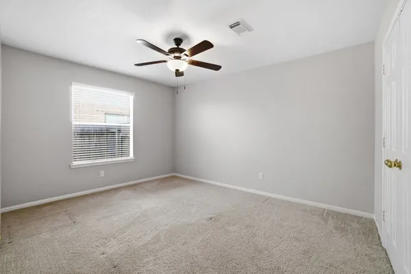 an empty room with closet and fan