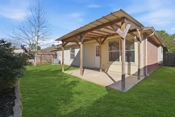 a view of a house with a yard and tree