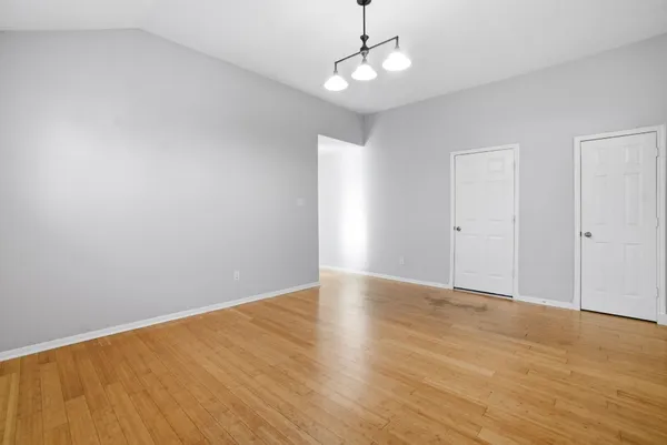 a view of empty room with wooden floor and ceiling fan