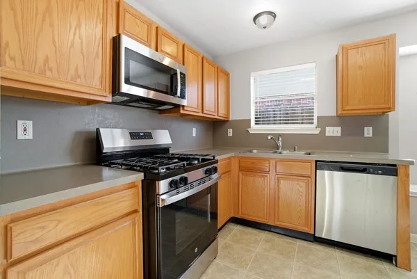 a kitchen with stainless steel appliances granite countertop a stove a sink and a microwave