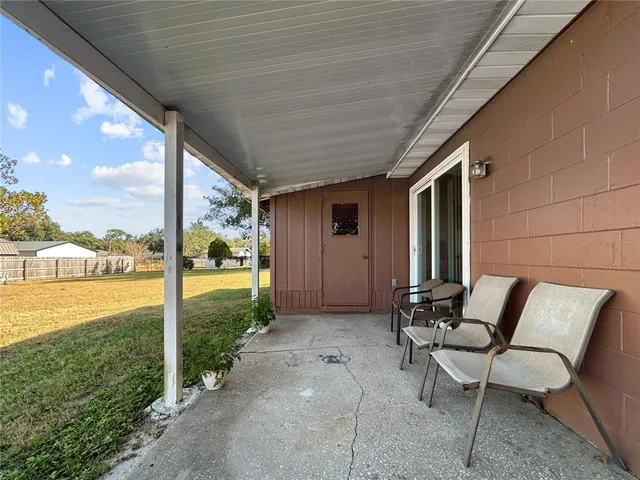 a view of a patio with a table chairs and garden