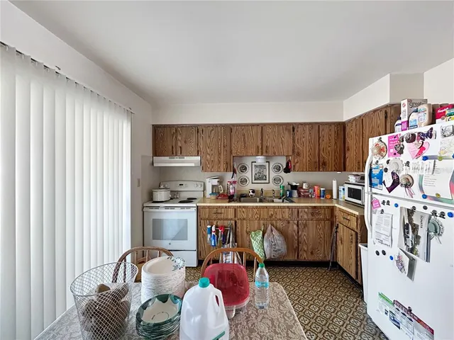 a kitchen with stainless steel appliances granite countertop a sink dishwasher and cabinets with wooden floor