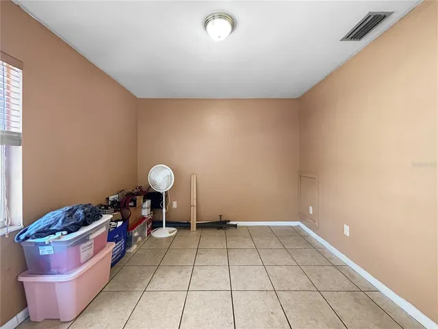 a room with water heater and wooden cabinets