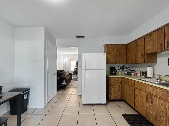a kitchen with a sink a refrigerator and cabinets