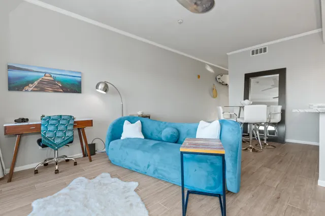 a living room with furniture a rug and a painting on the wall