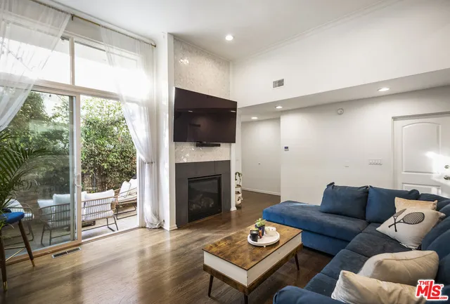 a living room with furniture a fireplace and a floor to ceiling window