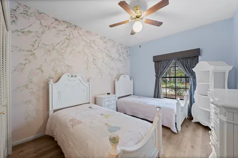 a bedroom with 2 bed and a window