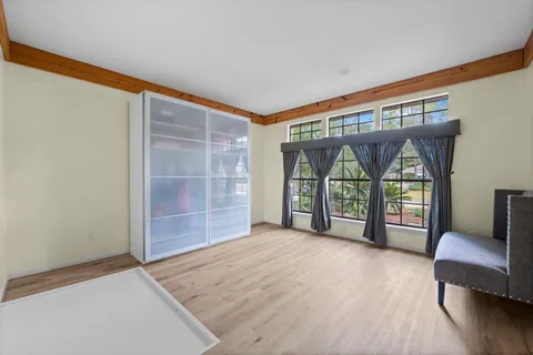 an empty room with furniture and a large window