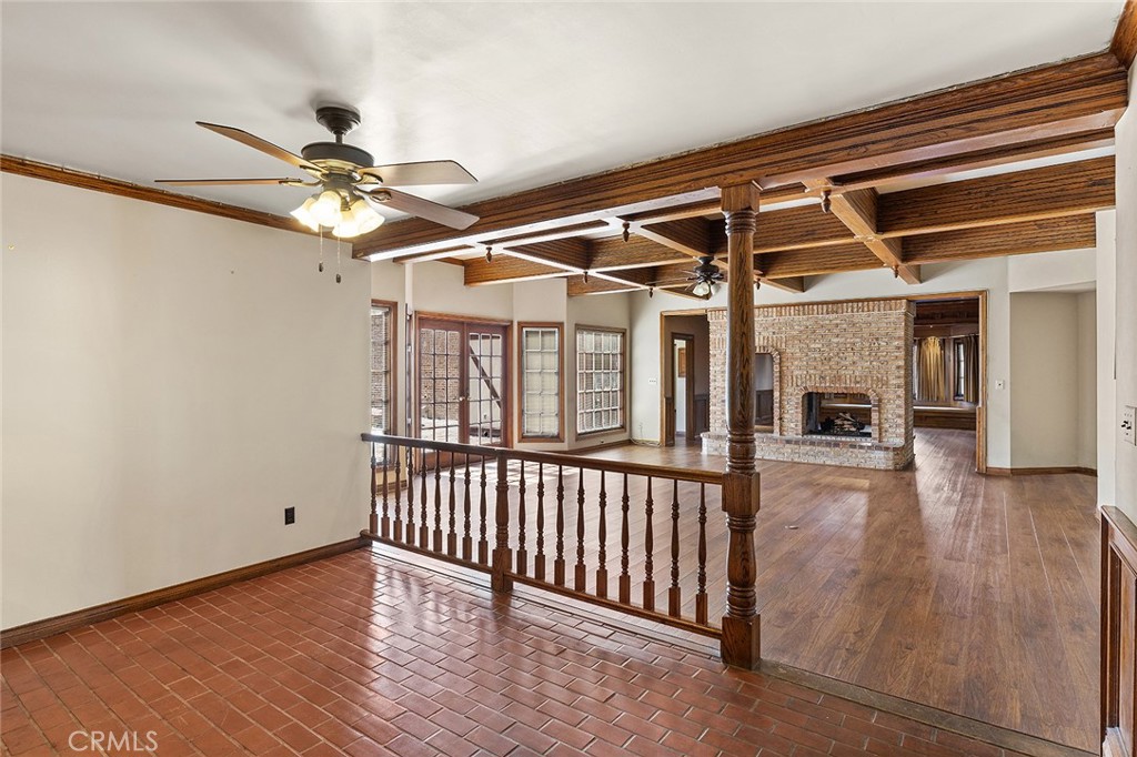 11550 183rd Street Artesia, CA 90701 - Photo 11 of 67 an empty room with wooden floor a ceiling fan and windows