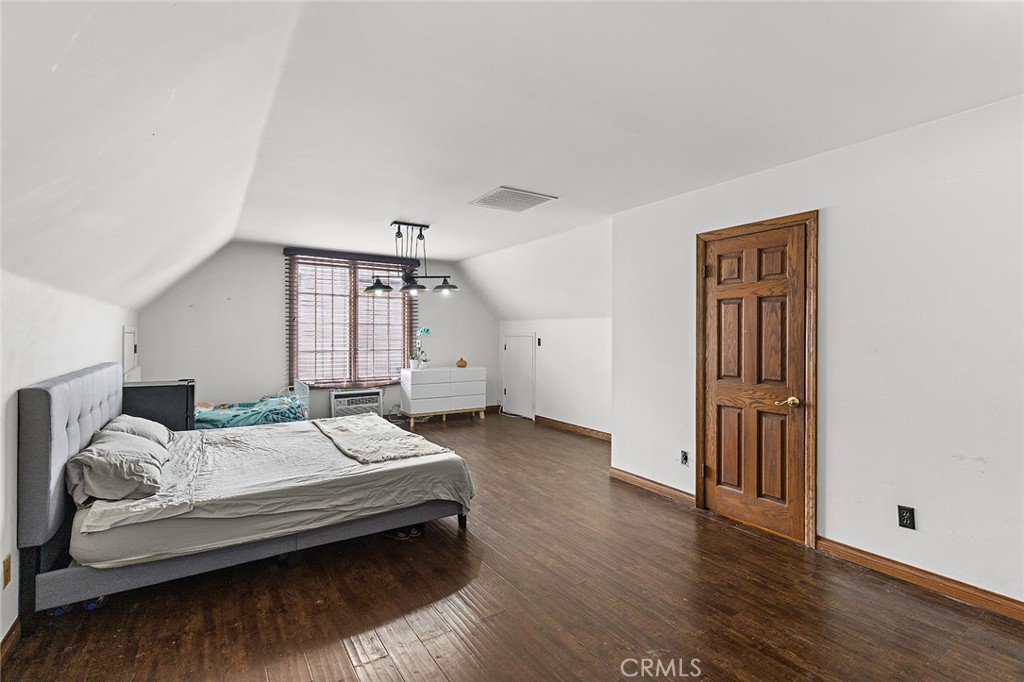 11550 183rd Street Artesia, CA 90701 - Photo 25 of 67 a bedroom with a bed wooden floor and window