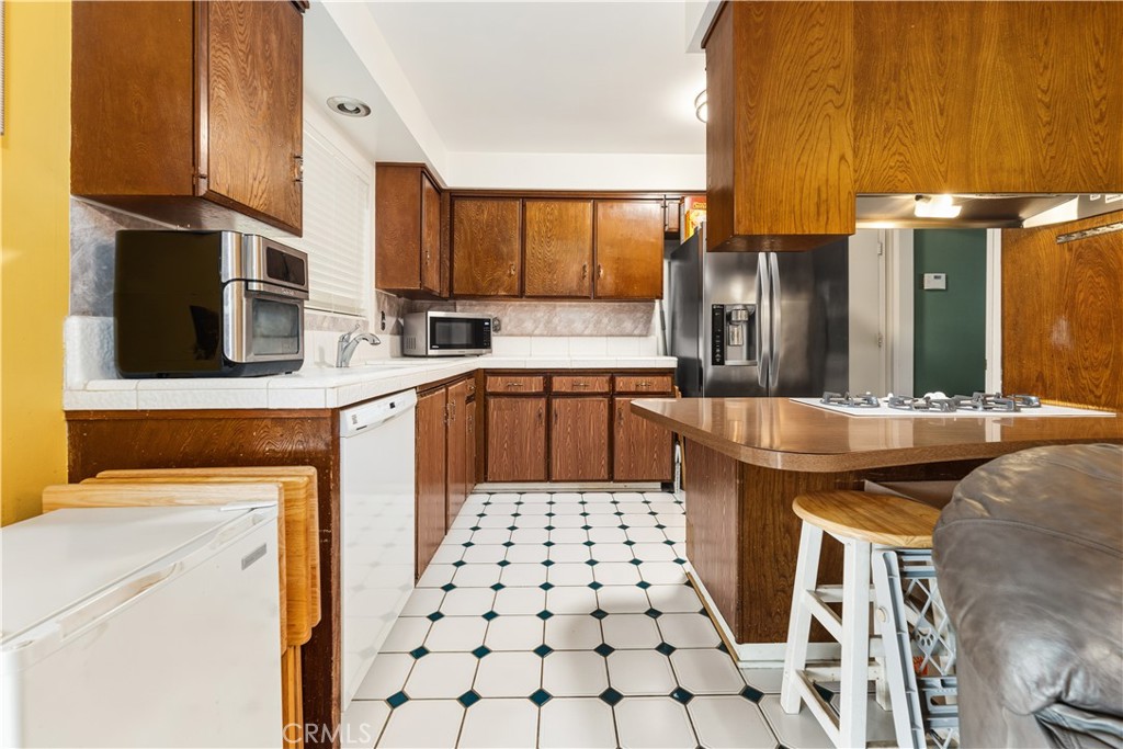 885 East Home Street Rialto, CA 92376 - Photo 11 of 26 a kitchen with stainless steel appliances a sink a stove a refrigerator and cabinets