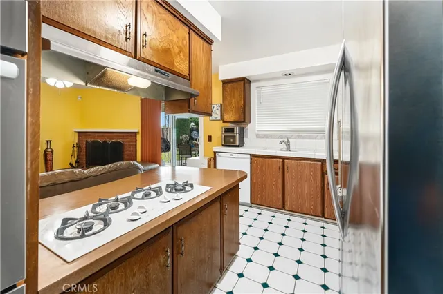 a kitchen with stainless steel appliances kitchen island granite countertop a refrigerator and a stove