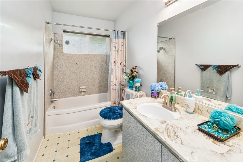 885 East Home Street Rialto, CA 92376 - Photo 17 of 26 a bathroom with a granite countertop sink a toilet and shower