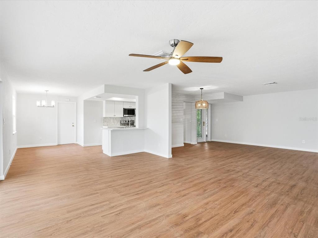 235 Pompano Terrace Punta Gorda, FL 33950 - Photo 7 of 30 a view of a kitchen with wooden floor and a ceiling fan