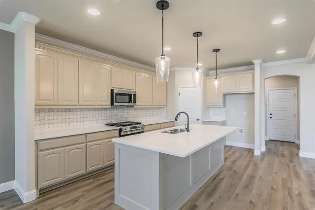 a kitchen with a sink stove and cabinets