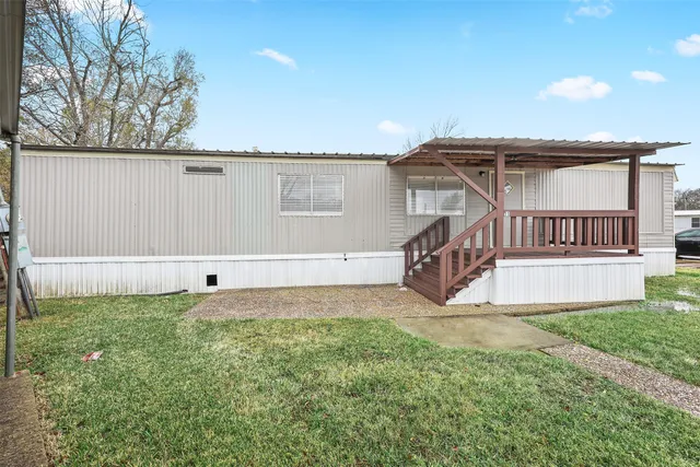 a view of a house with backyard and deck