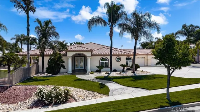 a front view of a house with garden and swimming pool