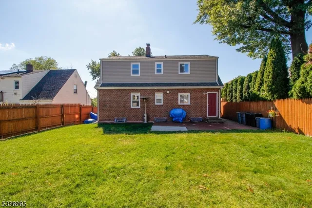 a view of a house with backyard and a tree