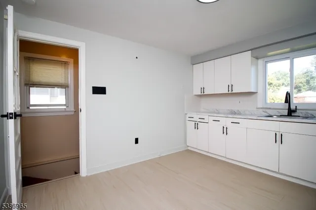 a kitchen with granite countertop white cabinets and white appliances