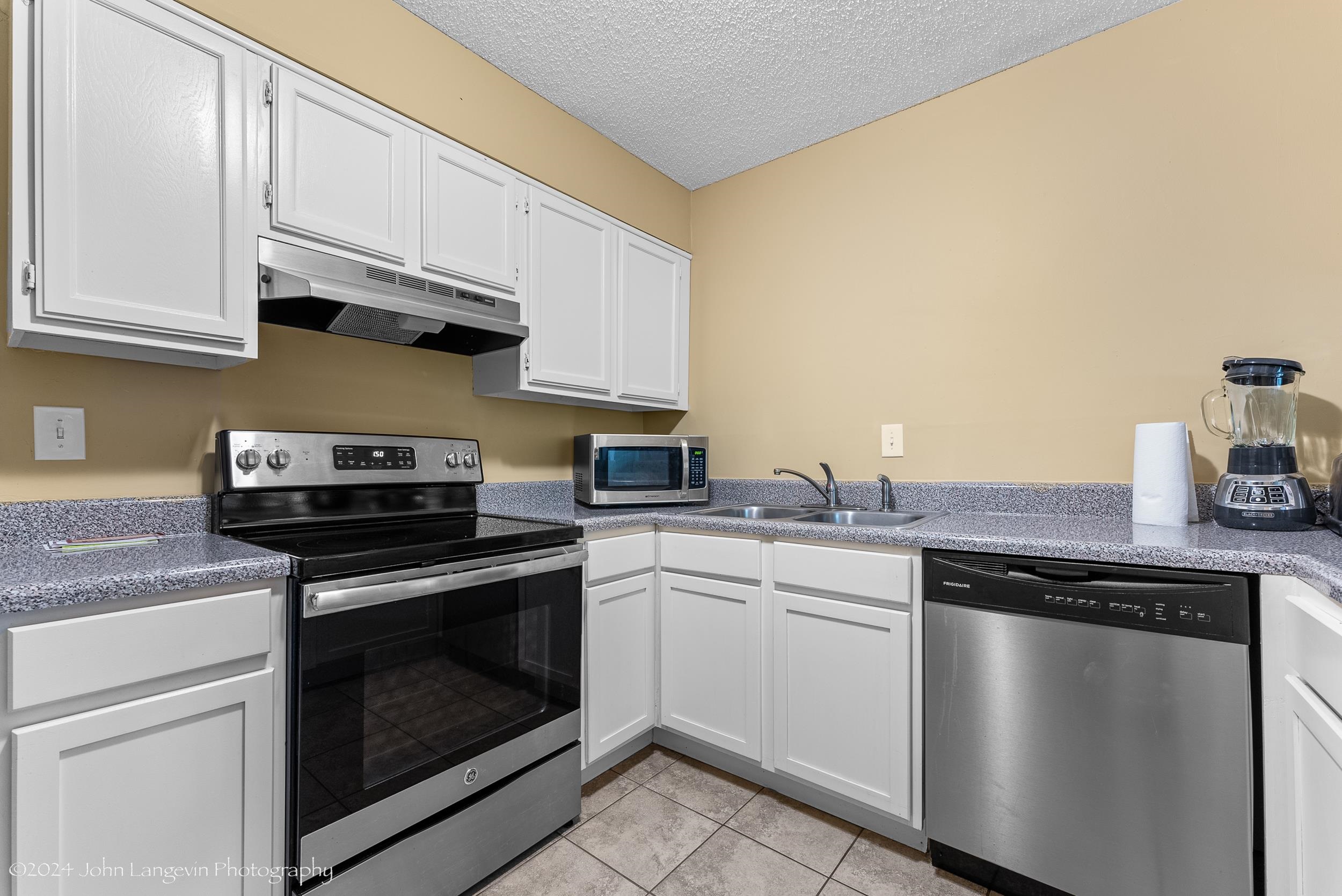 3118 Knob Hill Road Lakeland, TN 38002 - Photo 8 of 27 Kitchen with stainless steel appliances, a textured ceiling, light tile floors, sink, and white cabinets