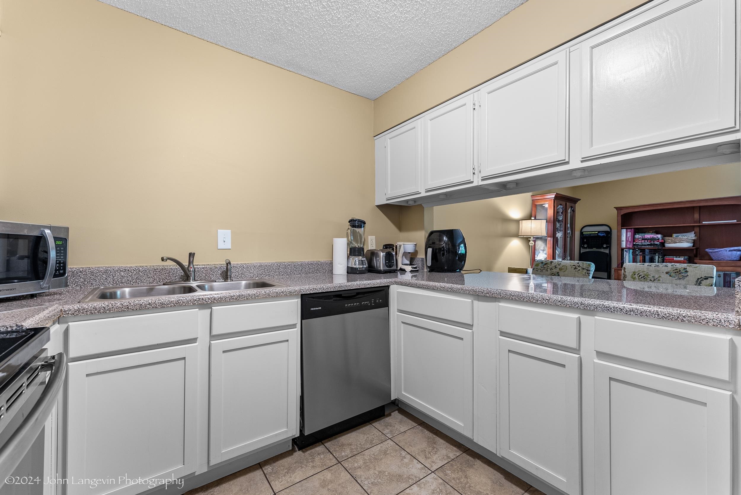 3118 Knob Hill Road Lakeland, TN 38002 - Photo 10 of 27 Kitchen featuring white cabinetry, a textured ceiling, stainless steel appliances, sink, and light tile floors