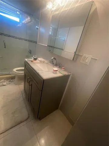 a view of a refrigerator in kitchen and an empty room