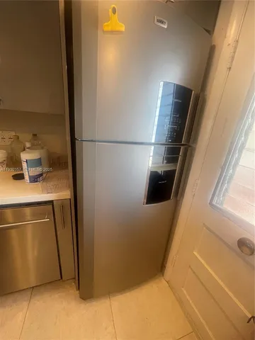 a room with water heater and wooden cabinets