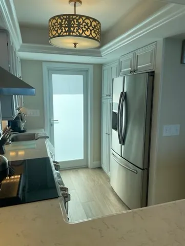 a kitchen with stainless steel appliances granite countertop a refrigerator a stove and a sink