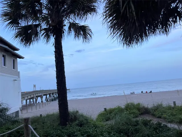 a view of ocean with beach and palm trees