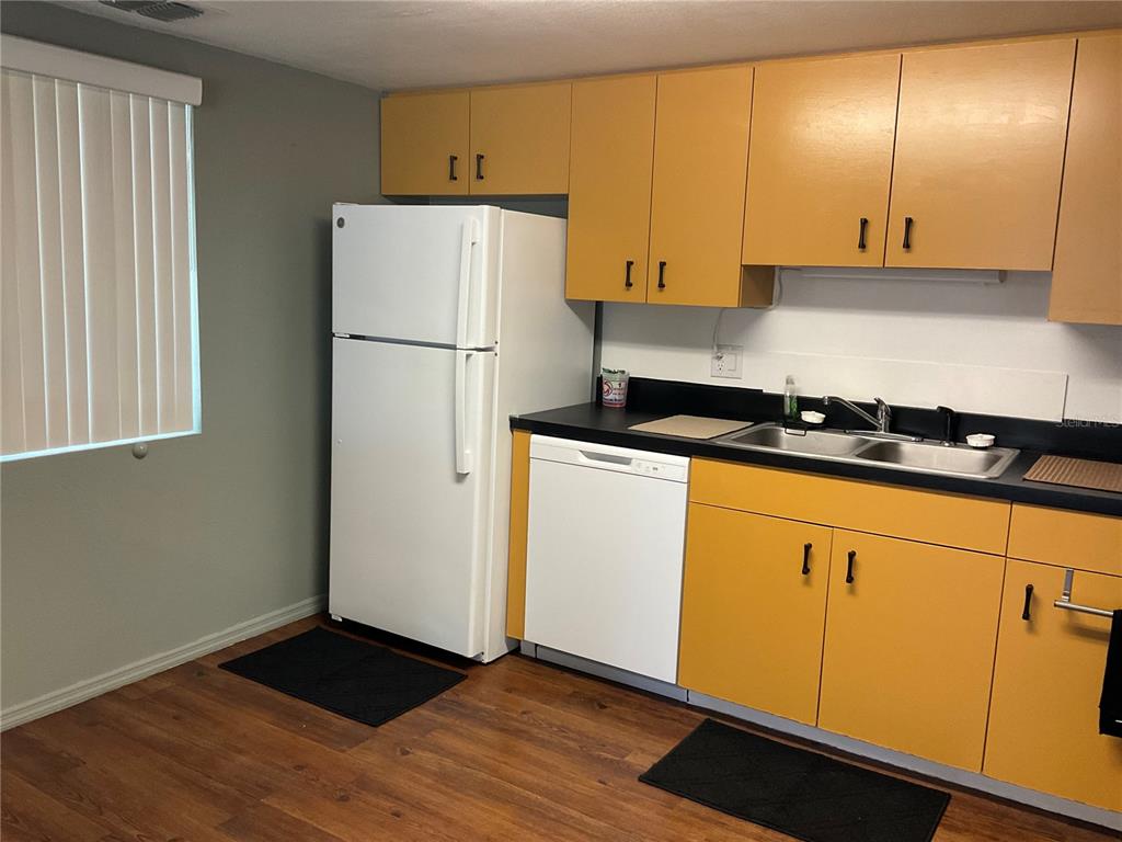 a kitchen with granite countertop cabinets and white appliances