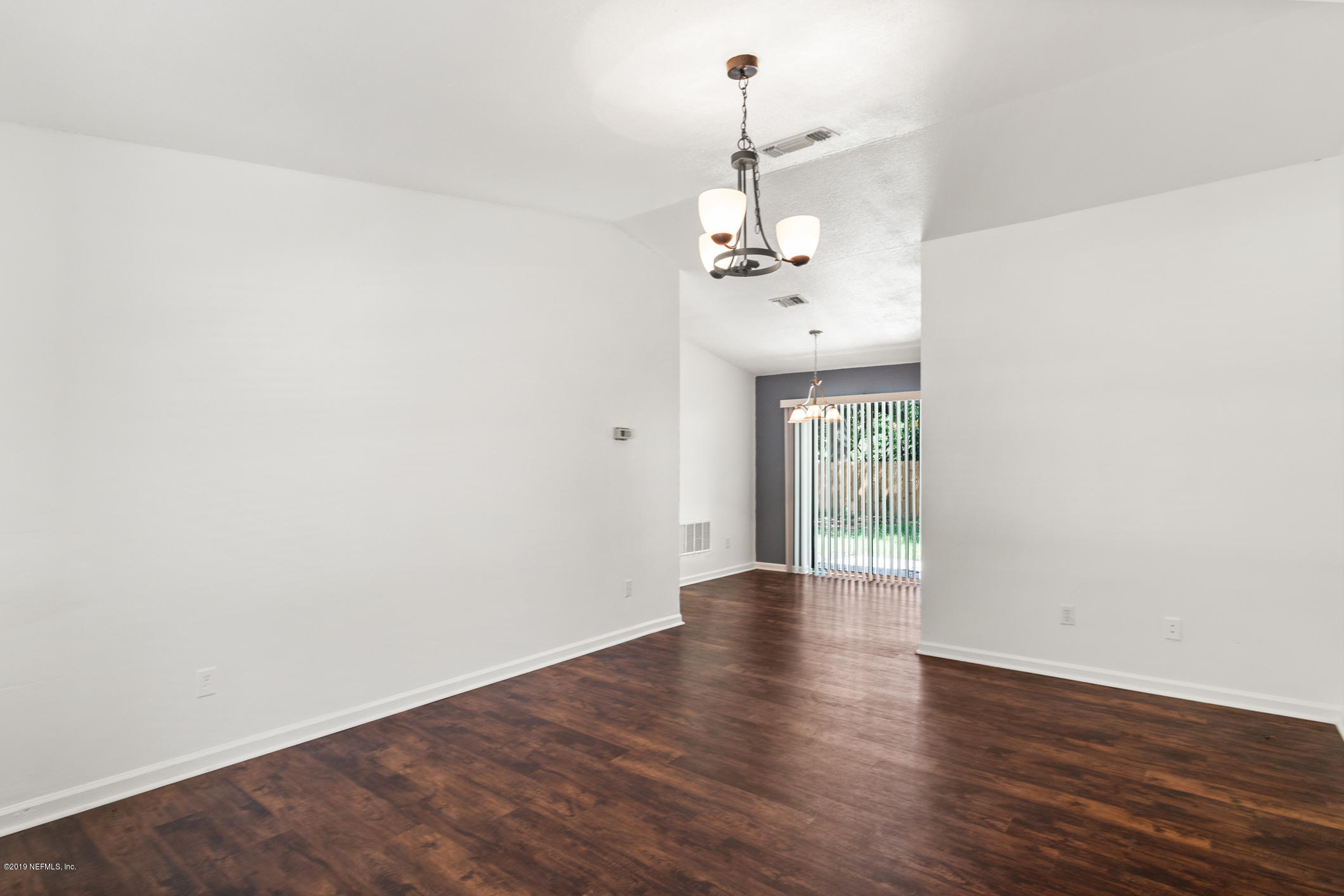 7163 Melvin Road Jacksonville, FL 32210 - Photo 11 of 33 a view of a room with wooden floor chandelier and a window