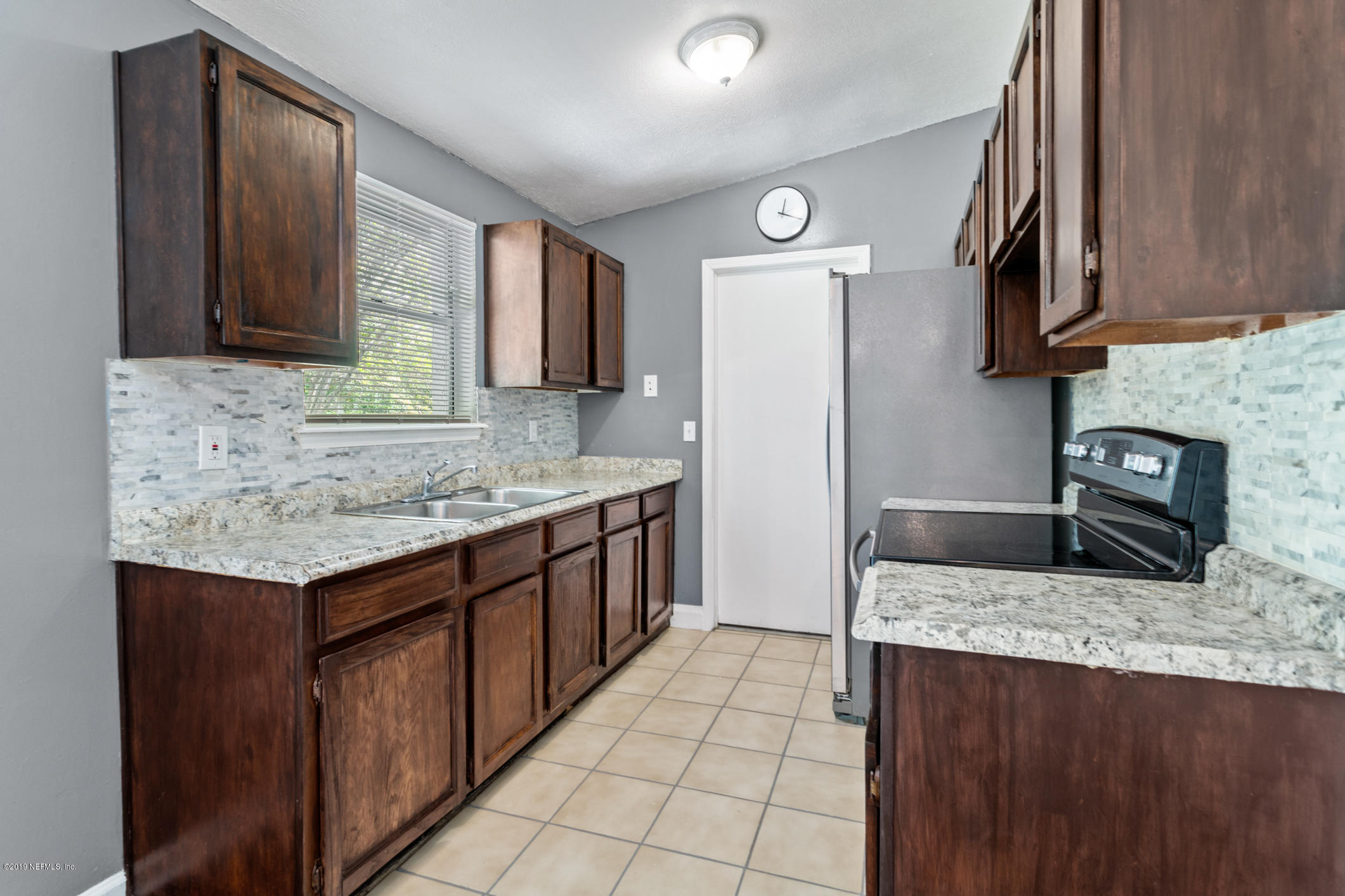 7163 Melvin Road Jacksonville, FL 32210 - Photo 12 of 33 a kitchen with stainless steel appliances granite countertop a sink stove and refrigerator