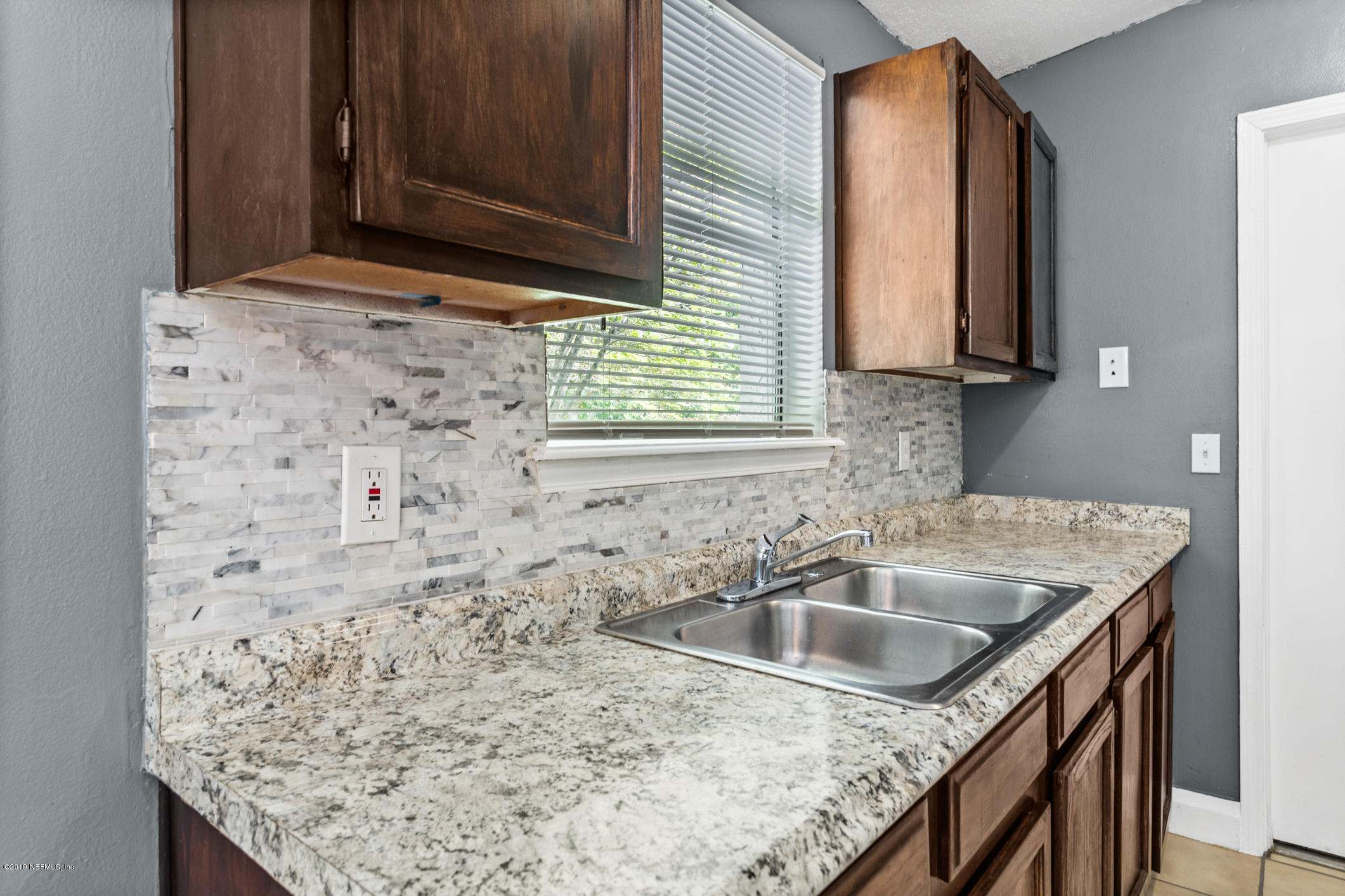 7163 Melvin Road Jacksonville, FL 32210 - Photo 15 of 33 a bathroom with a granite countertop sink and a mirror