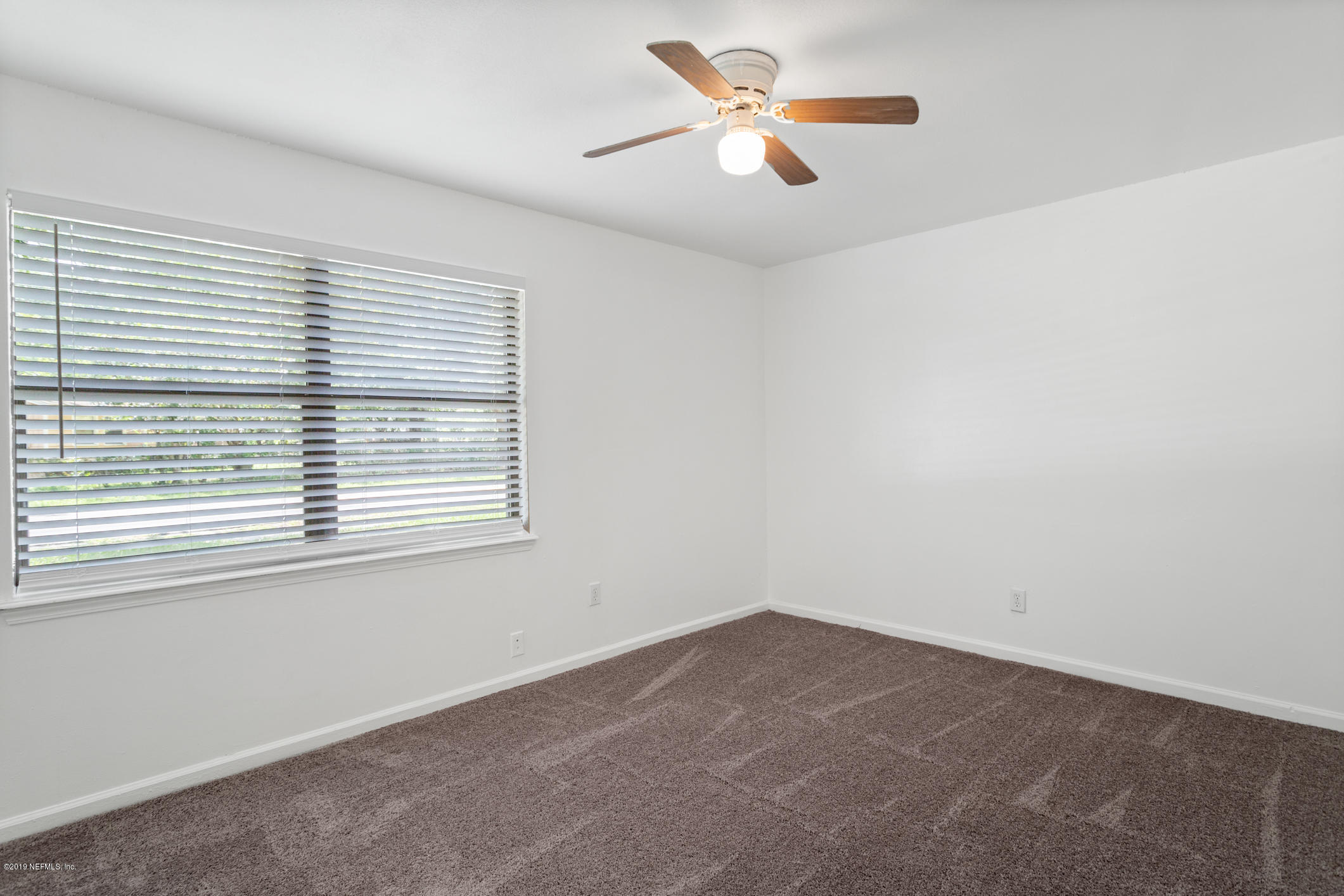 7163 Melvin Road Jacksonville, FL 32210 - Photo 20 of 33 an empty room with a window and a fan