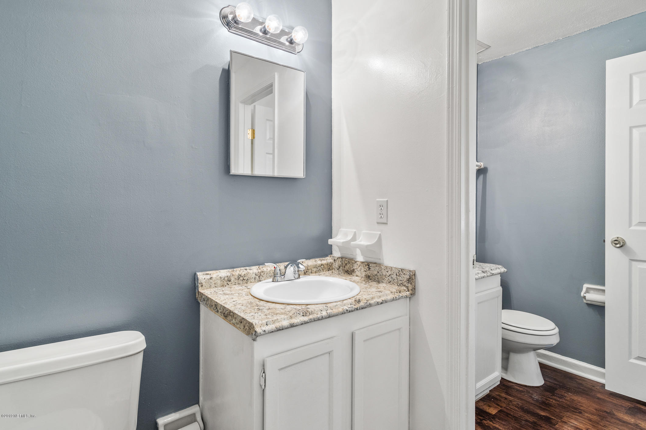 7163 Melvin Road Jacksonville, FL 32210 - Photo 21 of 33 a bathroom with a granite countertop toilet sink and mirror