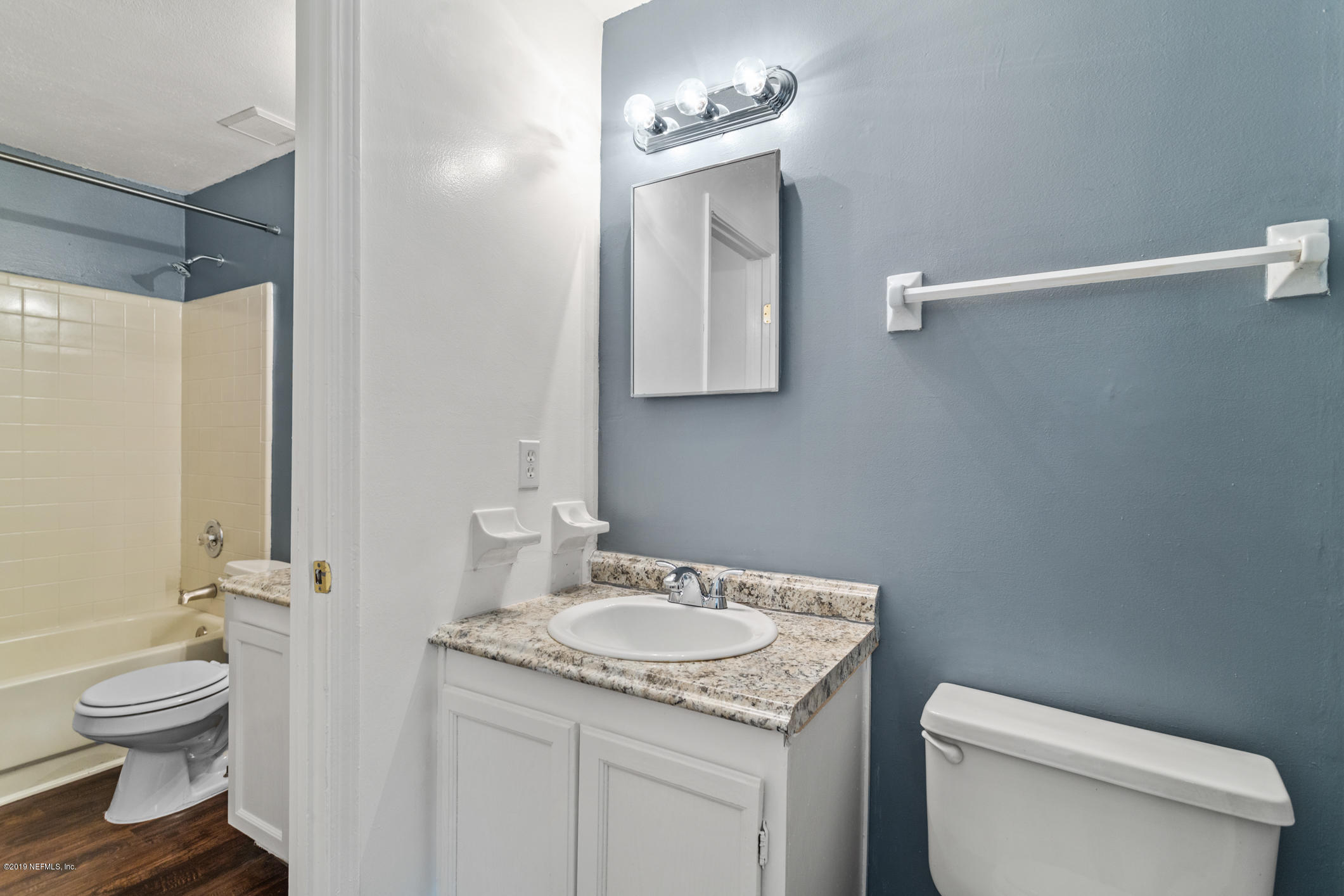 7163 Melvin Road Jacksonville, FL 32210 - Photo 23 of 33 a bathroom with a granite countertop sink toilet a mirror and shower