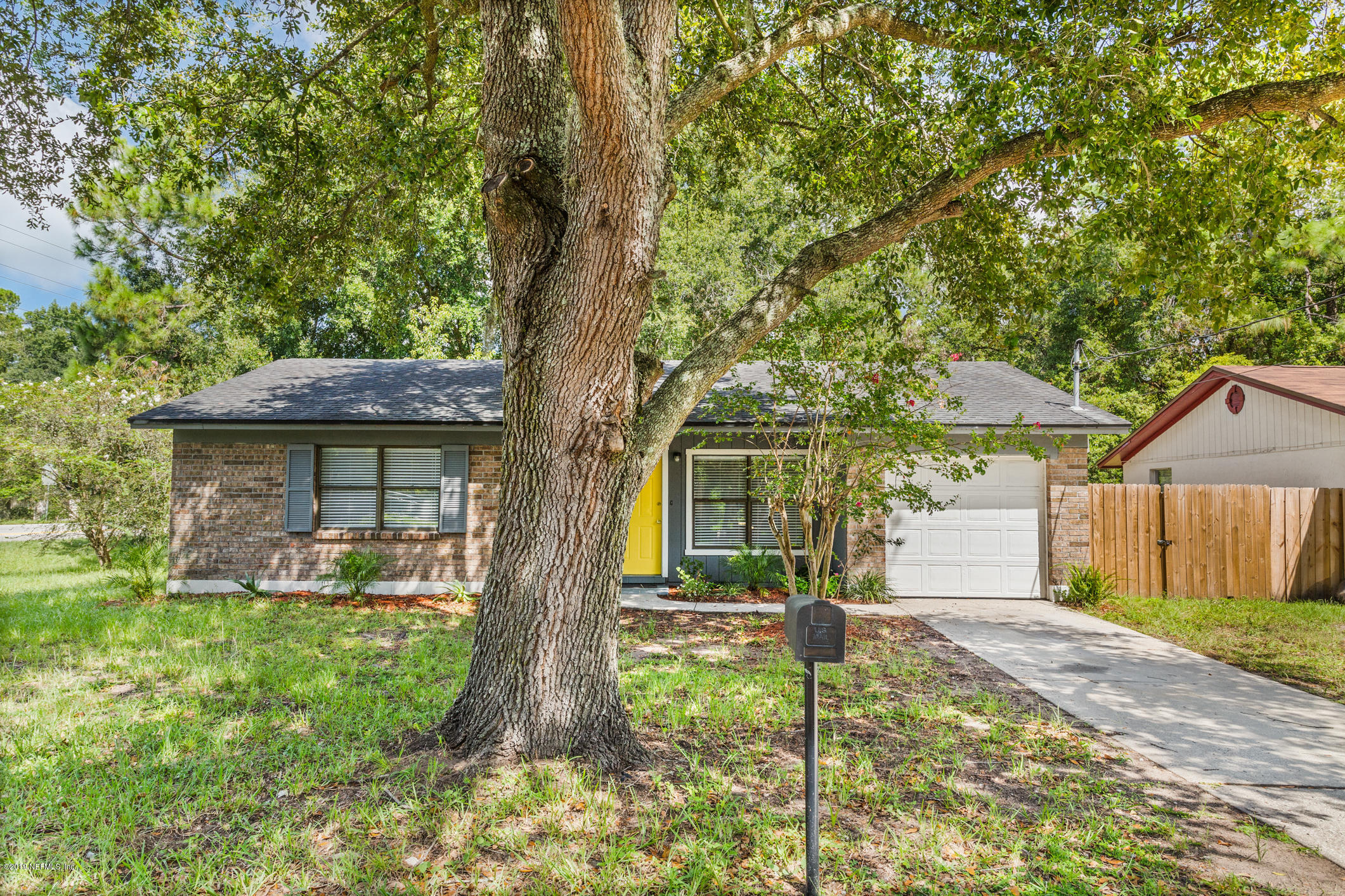 7163 Melvin Road Jacksonville, FL 32210 - Photo 3 of 33 a front view of a house with a yard and an tree