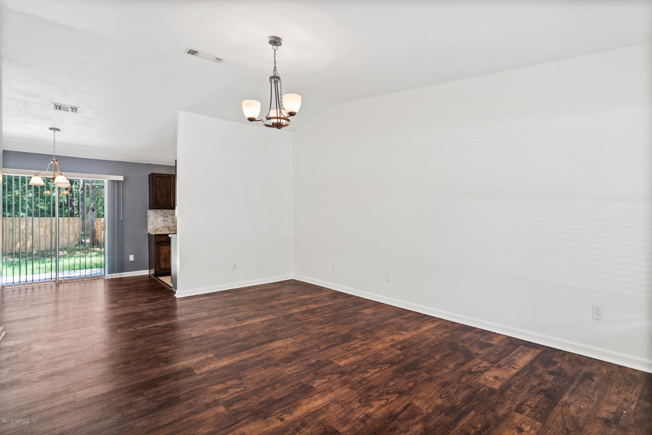 7163 Melvin Road Jacksonville, FL 32210 - Photo 9 of 33 wooden floor in an empty room with a window
