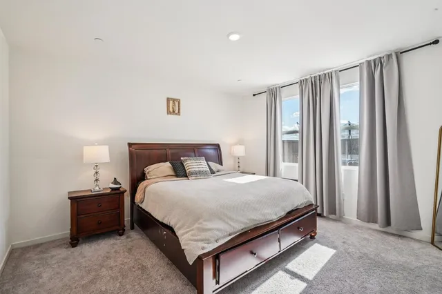 a bedroom with a bed lamp and a window