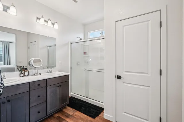 a en suite bathroom with a double vanity sink a mirror and shower