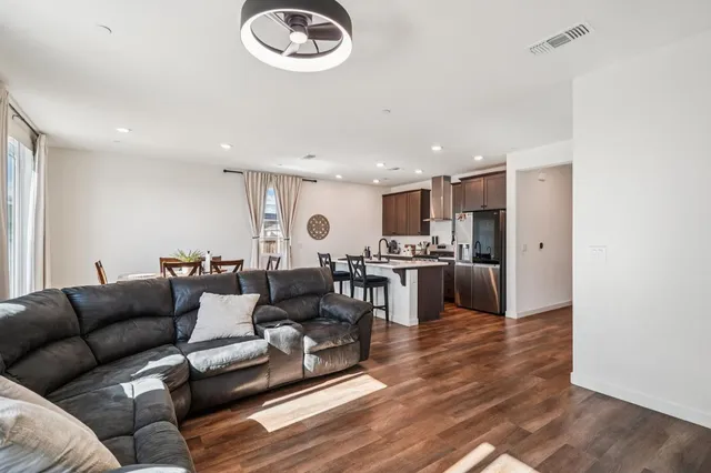 a living room with furniture kitchen view and a refrigerator
