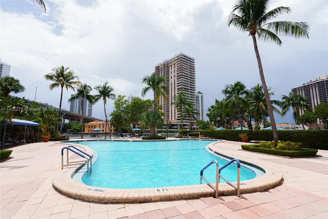 a swimming pool with some potted plants and palm trees