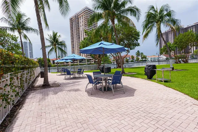 a view of a patio with a table and chairs under an umbrella